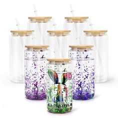 six clear glass jars with wooden lids are lined up in the shape of butterfly bottles