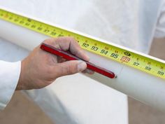 a person holding a measuring tape in their left hand and wearing a white coat on the other