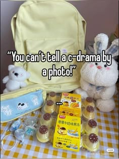 a teddy bear sitting next to a backpack and other items on a table with the words you can't tell a - drama by a photo