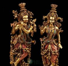 two golden statues are standing next to each other