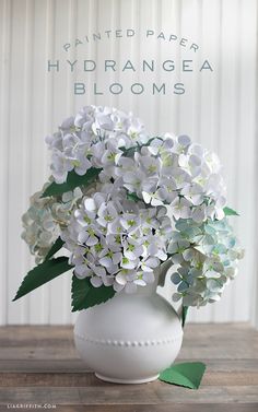 a vase filled with white flowers on top of a wooden table