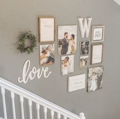 the wall is decorated with many pictures and frames for wedding photos, which are hung on the stair rail