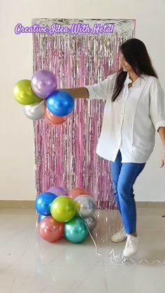 a woman standing in front of balloons and streamers