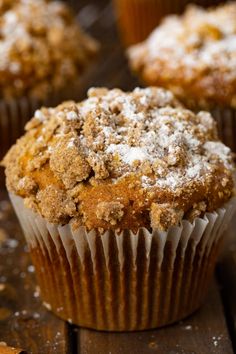 muffins with powdered sugar on top sitting on a wooden table