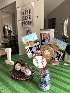 a table topped with pictures and baseballs on top of a green tablecloth covered table