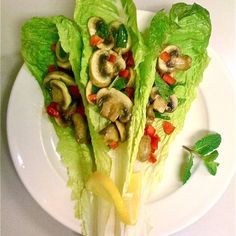 lettuce wraps with mushrooms and peppers on a white plate, ready to be eaten