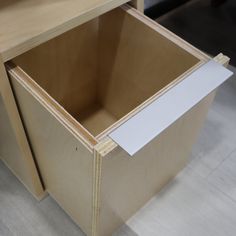 an open drawer with a white paper sticking out of it's bottom compartment on the floor