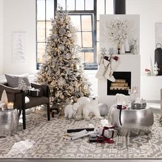 a living room decorated for christmas with white and silver decorations