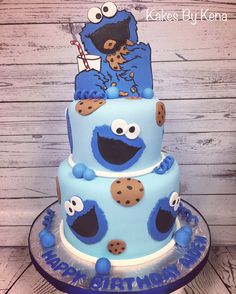 a three tiered cake decorated with blue icing and cookies