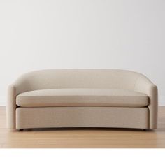 a beige couch sitting on top of a hard wood floor