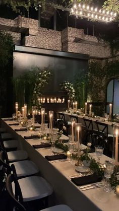 the long table is set with candles and greenery