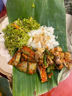 the meal is prepared and ready to be eaten on the big leafy platter