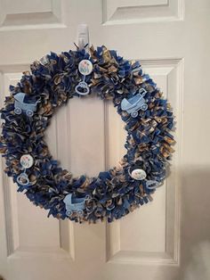 a blue wreath is hanging on the front door with buttons and other things attached to it