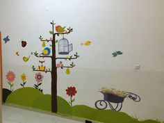 a wall with birds, flowers and a birdcage painted on it's side