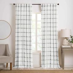 the white and black plaid curtains are hanging in front of a window with a mirror