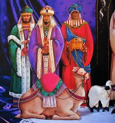 three wise men standing next to each other in front of a purple background with sheep