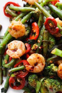 a white plate topped with vegetables and shrimp