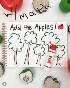 an apple themed notebook with the words add the apples written on it next to rocks and leaves