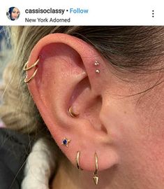 a close up of a person's ear with three different piercings on it