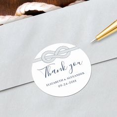 a close up of an envelope with a thank you sticker on it and a pen