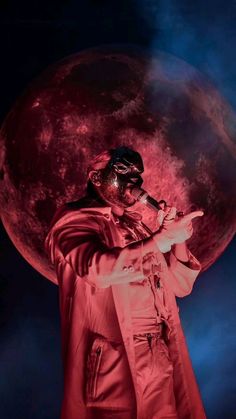 a man in a red suit and mask holding a pipe with the moon behind him