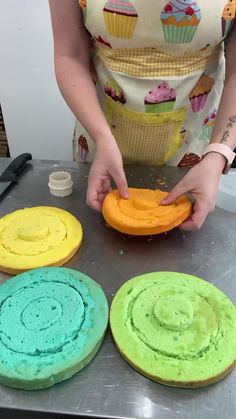 the woman is making colorful cakes on the table