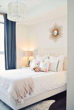 a bedroom with a white bed and chandelier