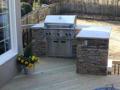 an outdoor kitchen with grill and seating area