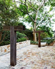 an outdoor area with brick pavers and trees