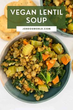 two bowls filled with vegetable soup and crackers on the side, one bowl is full of vegetables