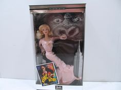 a barbie doll in a box with a gorilla face on it's head and an advertisement for the movie now