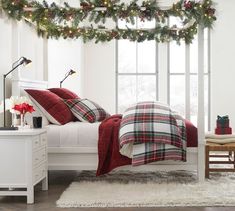 a bedroom decorated for christmas with garland and lights