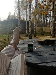 someone's feet resting on a table with an open book