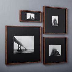 three black and white photos hanging on the wall next to each other with wooden frames