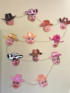 a group of children's hats hanging on a wall with numbers and faces attached to them