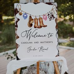 a welcome sign with boots and hearts hanging from it's clothesline on a wooden easel