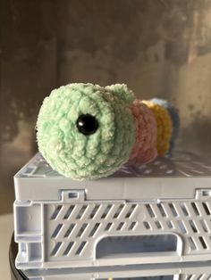 a stuffed animal sitting on top of a plastic container