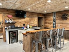 a kitchen with wooden walls and bar stools