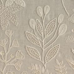 an embroidered fabric with white flowers and leaves on grey background, suitable for wallpaper or upholstering