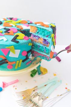 a person is cutting into a colorful cake