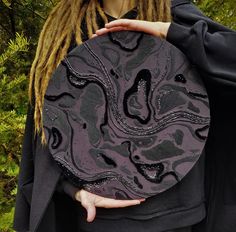 a woman with dreadlocks holding a black and grey plate