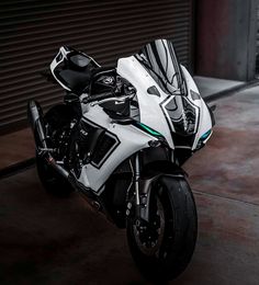 a white motorcycle parked in front of a garage door