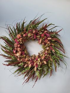 a wreath made out of dried flowers and grass