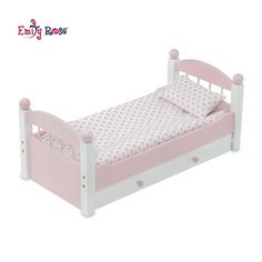 a pink and white doll bed with polka dot sheets on it's bottom half