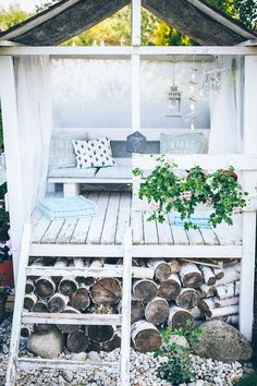 a gazebo made out of logs and some plants