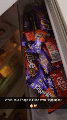 a refrigerator filled with lots of different types of candy bar wrappers in it's door