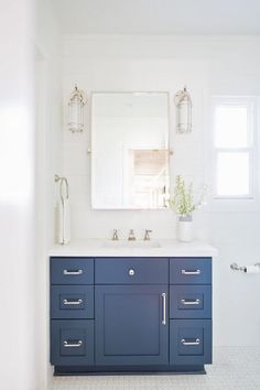 a white and blue bathroom with two sinks