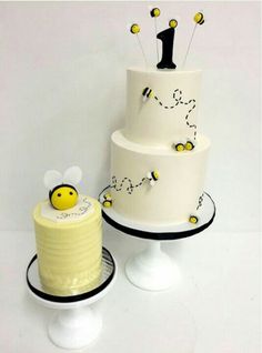 two tiered cake with yellow and black decorations on each layer, one has a bee topper