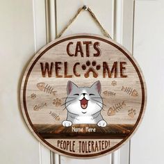 a wooden sign that says cats welcome home there is a cat on the front door