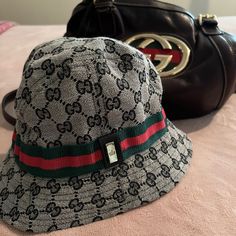 Authentic Gucci Bucket Hat. Childs Large Or Adult Xsmall. Gray With Black Gg Logo And Gucci Trademark Red And Green Band That Goes Around The Hat With Silver Gucci Strip. Silk Black Gg Logo Lining Is Ripped And Frayed But Does Not Affect Wearing The Hat. Grey Gucci Bucket Hat, Gucci Bucket Hat, Gucci Accessories, Kids Accessories, Bucket Hat, Accessories Hats, Black And Grey, Gucci, Band